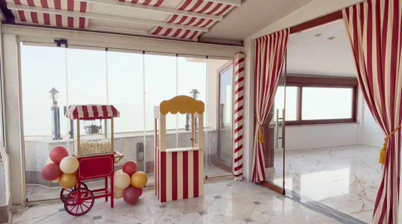 Circus concept for a children's birthday: circus entrance at the glass door, ticket booth and popcorn