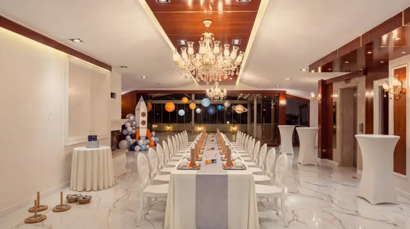 Space concept for a children's birthday: full-length view of the hall from the buffet end