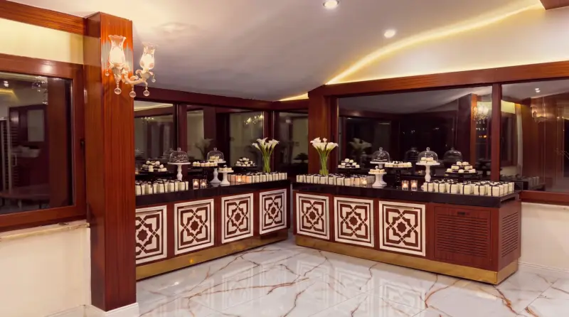 تصميم «أبنوس» لحفل الزفاف: حلويات بتي فور بالأسود والأبيض على منضدة الضيافة على شكل L