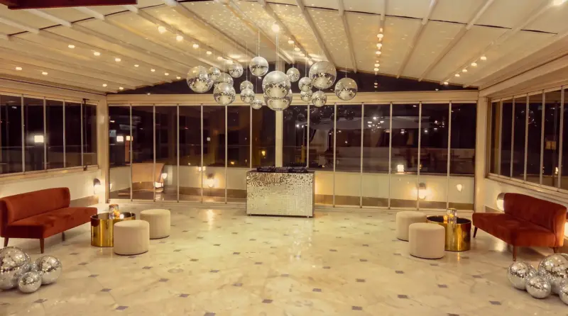 Disco concept for an adult birthday: cluster of mirror balls and DJ corner on the terrace