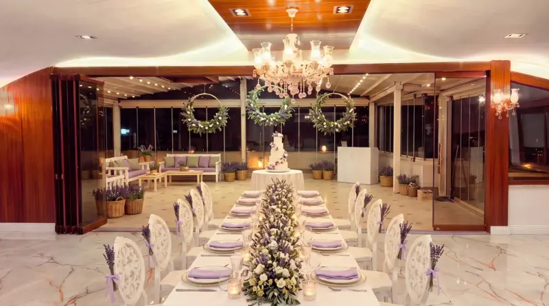 Lavender concept for an adult birthday: long table and cake in the hall, terrace beyond