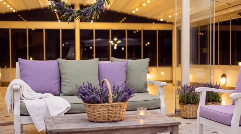 Lavender concept for an adult birthday: close-up of terrace lounge seating and a floral hoop