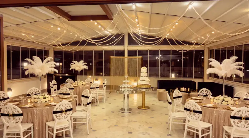 Champagne concept for an adult birthday: pearl swags, champagne tower and cake on the terrace