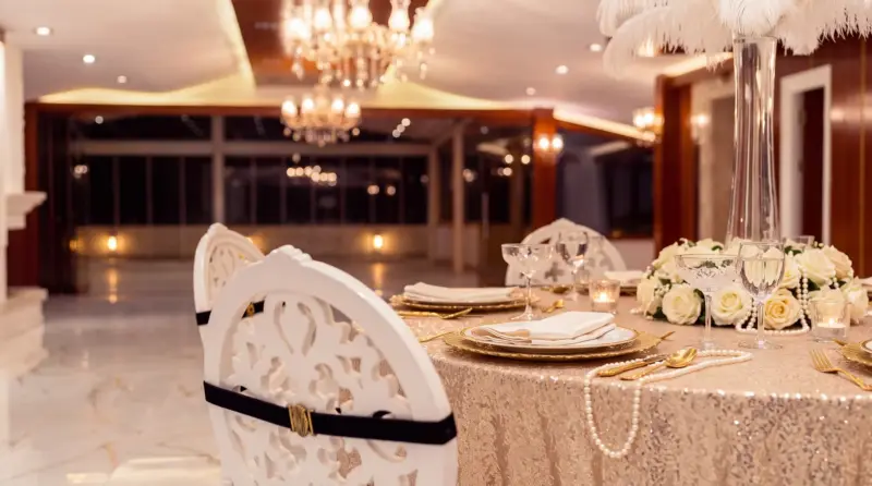 Champagne concept for an adult birthday: close-up of a feather decoration on a round table