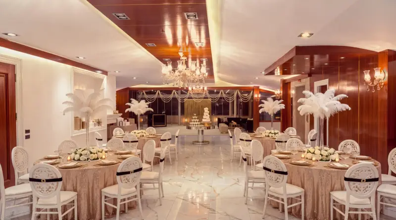 Champagne concept for an adult birthday: round tables, diagonal view from the buffet corner